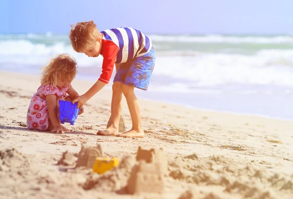 Barn leker med sand på sommaren stranden — Stockfoto