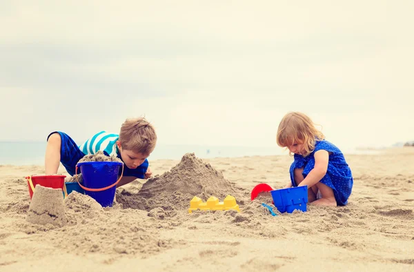 Gyerekek játszanak homokkal a nyári strandon — Stock Fotó