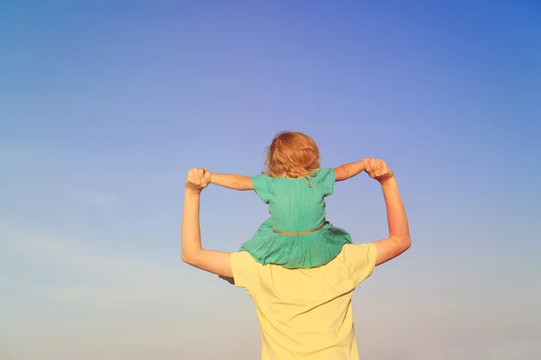 Pai e pequena filha nos ombros brincam no céu — Fotografia de Stock