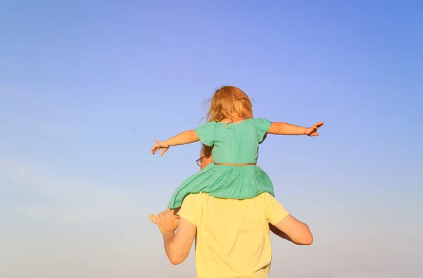 Батько і маленька дочка на плечах грають на небі — стокове фото