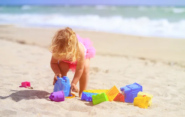 Little girl plays with sand on beach — Stock Photo, Image