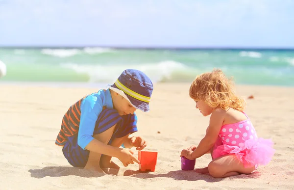 Barn leker med sand på sommaren stranden — Stockfoto