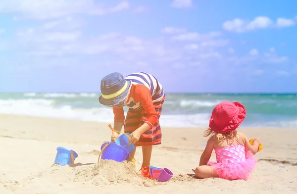 Kids play with sand on summer beach — Stock Photo, Image