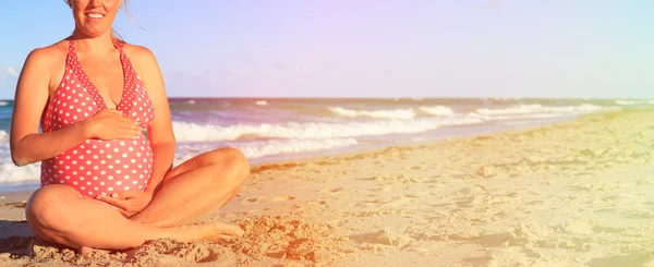 Счастливая беременная женщина на пляже — стоковое фото