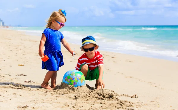 Kids play with globe at the beach — Stock Photo, Image