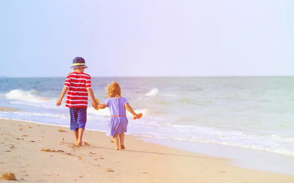 Jongen en meisje lopen op strand — Stockfoto