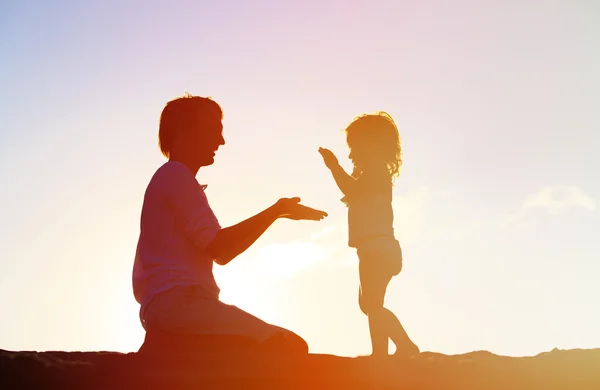 Father and little daughter silhouettes at sunset Royalty Free Stock Images