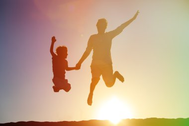 Baba ve oğul günbatımı gökyüzü atlama