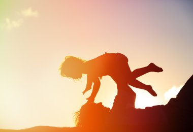 Baba ve kızı günbatımında oynamak