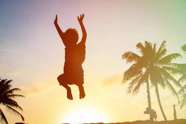 Boy jumping at sunset beach — Stock Photo, Image