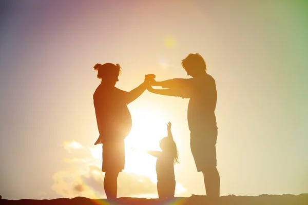 Familj med barn och gravida modern vid solnedgången — Stockfoto
