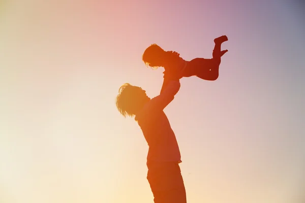 Father and little daughter play at sunset — Stock Photo, Image