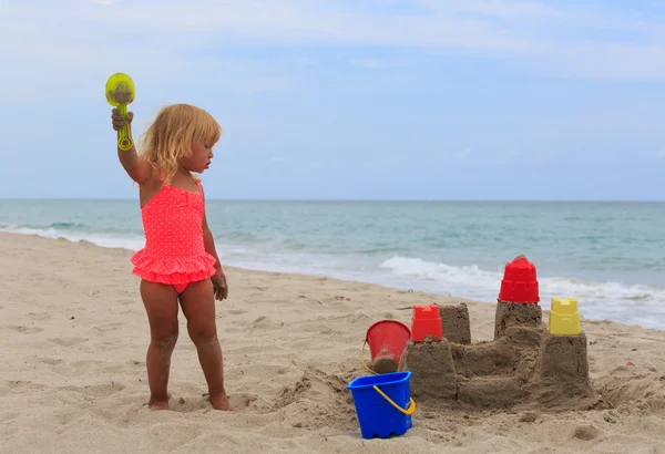 Chica juega con arena en la playa — Foto de Stock