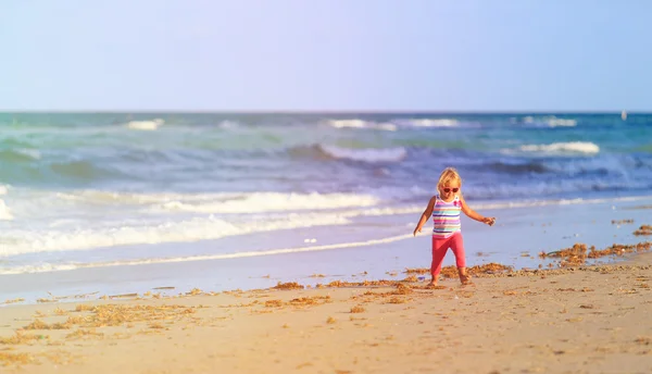 Little girl walks on sand beach — Stock Photo, Image