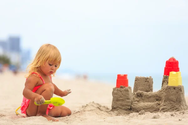Ragazza gioca con sabbia e giocattoli sulla spiaggia — Foto Stock