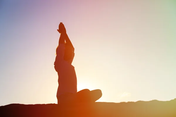 Jeune homme faisant du yoga au coucher du soleil — Photo