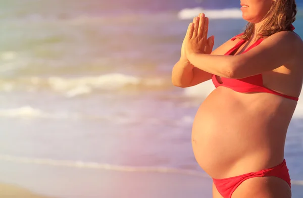 Kobieta w ciąży praktykowania jogi na plaży — Zdjęcie stockowe