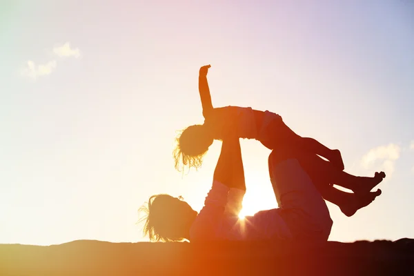 Vader en dochter spelen bij zonsondergang — Stockfoto