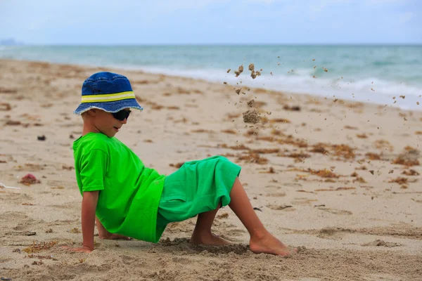 Chłopiec bawi się piasek na plaży latem — Zdjęcie stockowe