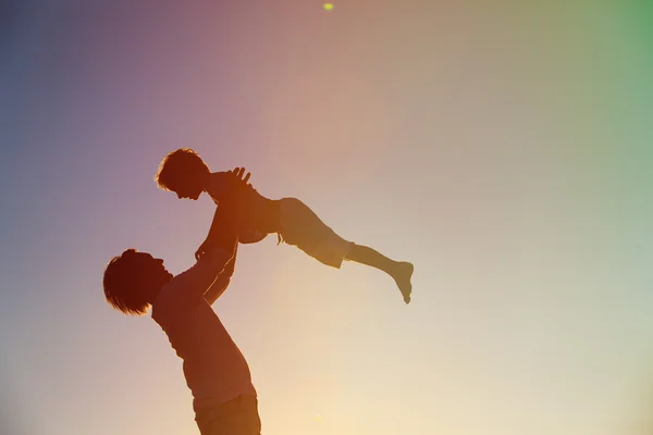 Pai e filho brincam ao pôr do sol — Fotografia de Stock