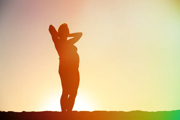 Silhouette of pregnant woman at sunset — Stock Photo, Image