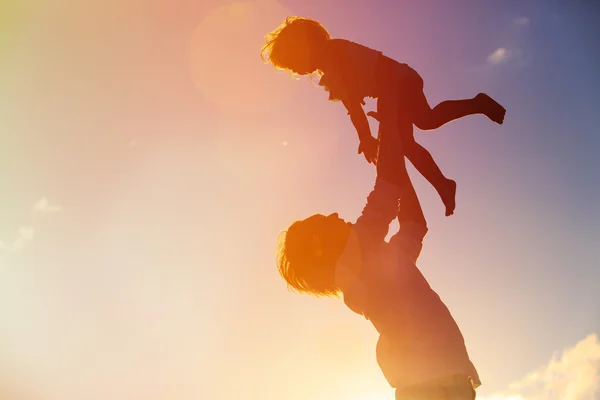 Vader en dochter spelen bij zonsondergang — Stockfoto