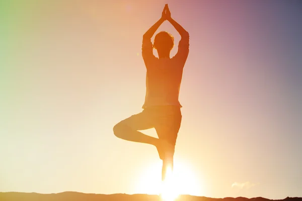 Молодий чоловік робить йогу на заході сонця — стокове фото
