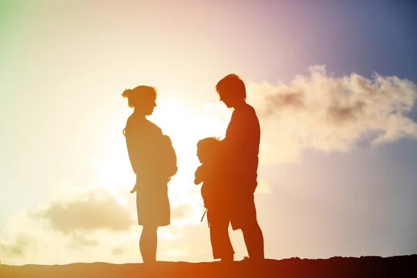 Gravida mamma med far och son i solnedgången — Stockfoto