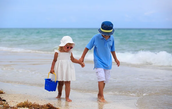 Jongen en meisje lopen op strand — Stockfoto