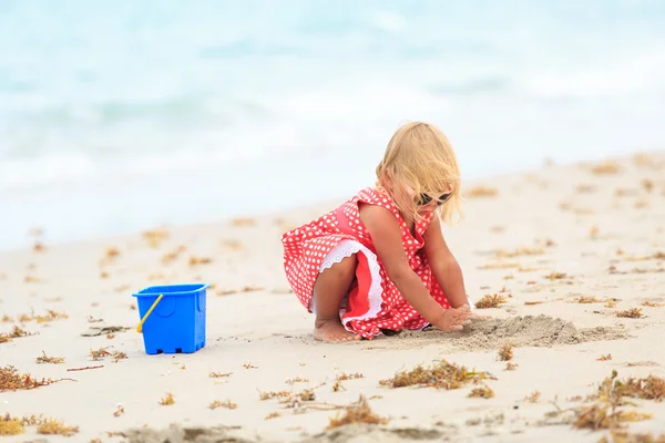Dívka hraje s pískem na pláži — Stock fotografie