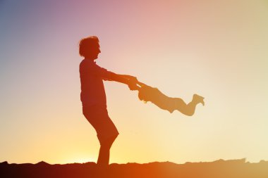 Baba ve kızı günbatımında oynamak