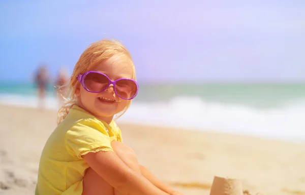 女の子は、ビーチで砂で遊ぶ — ストック写真