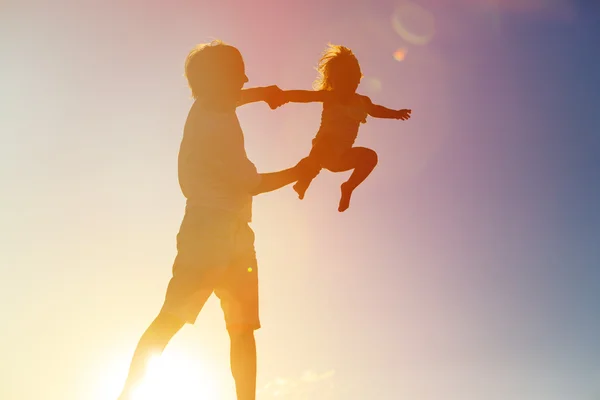 Vader en dochter spelen bij zonsondergang — Stockfoto