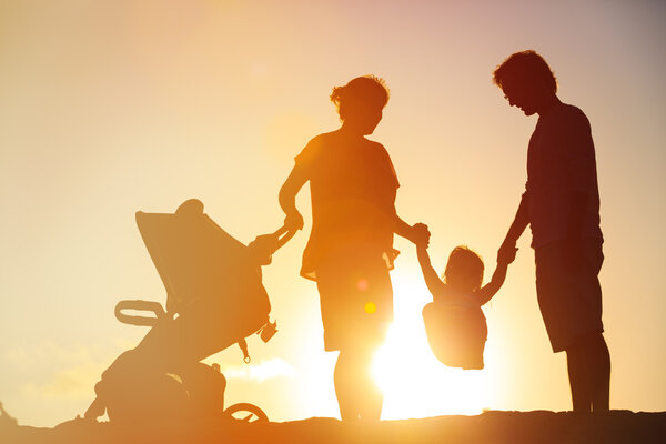 семья с ребенком и коляска играть на закате
