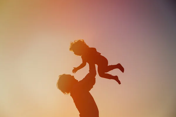 Vader en dochter spelen bij zonsondergang — Stockfoto