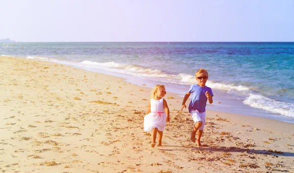 男孩和女孩在海滩上跑 — 图库照片