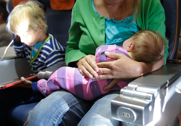 Madre con bebé e hijo pequeño en avión — Foto de Stock