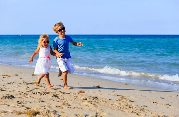 Kleine jongen en meisje draait op strand — Stockfoto