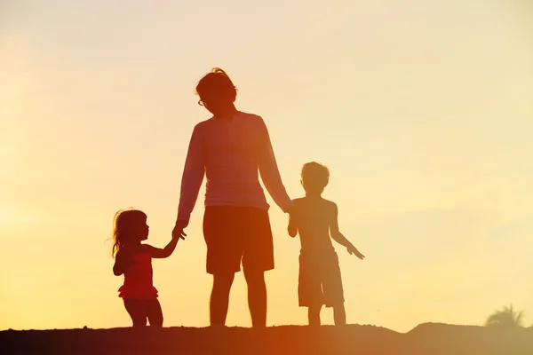 Vader en zoon en dochter lopen bij zonsondergang — Stockfoto