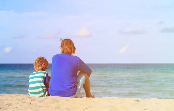 Vader en zoon praten op strand — Stockfoto