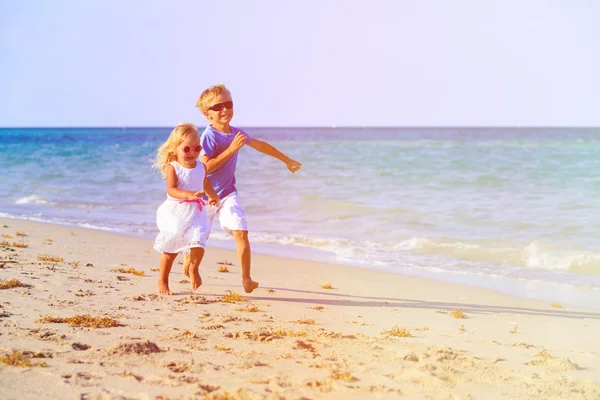 Chłopak i dziewczyna działa na plaży — Zdjęcie stockowe