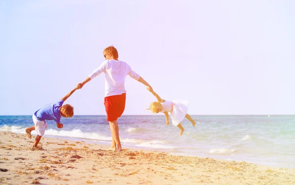 Vader en zoon en dochter spelen op strand — Stockfoto