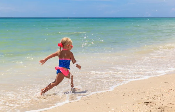 Meisje met de golven op het strand — Stockfoto