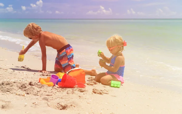 Menina bonito brincando com areia na praia — Stock Photo 