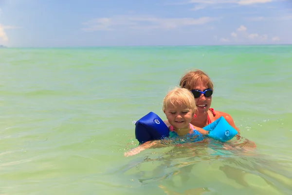 Madre enseñando hija a nadar en el mar — Foto de Stock