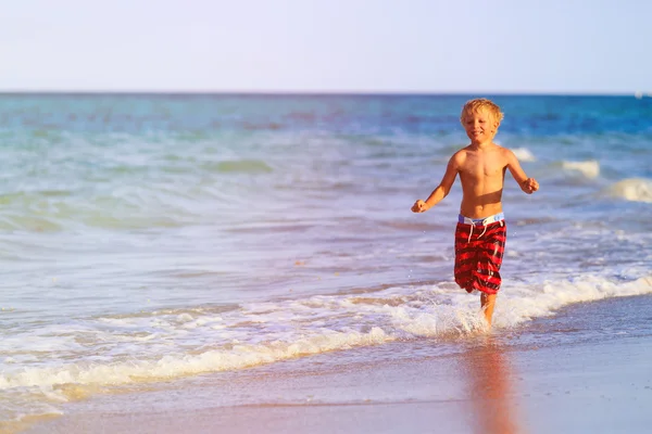 Хлопчик біжить на піщаному пляжі — стокове фото