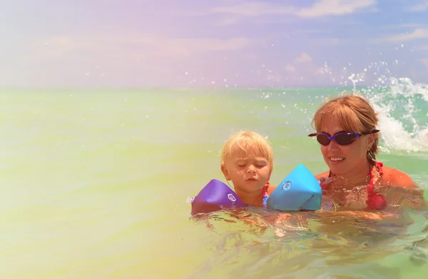 Mãe ensinando filha a nadar no mar — Fotografia de Stock