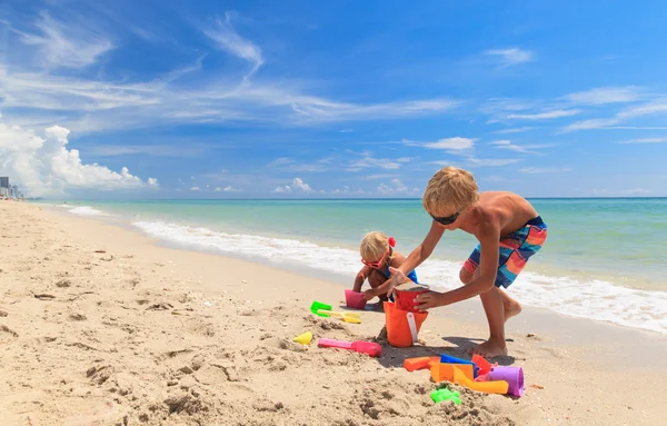 kids play with sand on beach