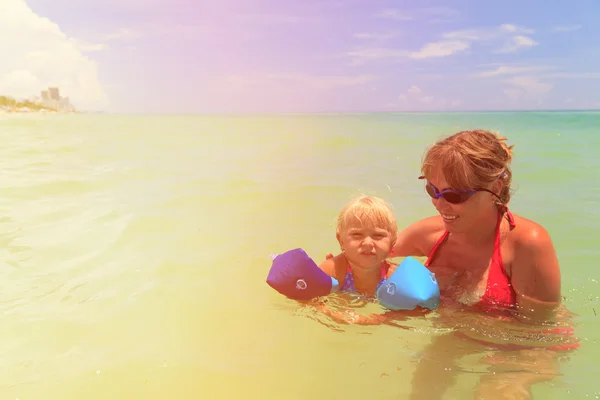 Madre enseñando hija a nadar en el mar — Foto de Stock