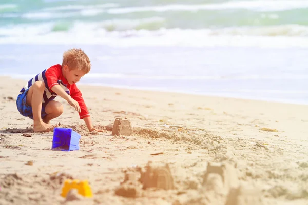 Fiú játszik a homok a strandon — Stock Fotó